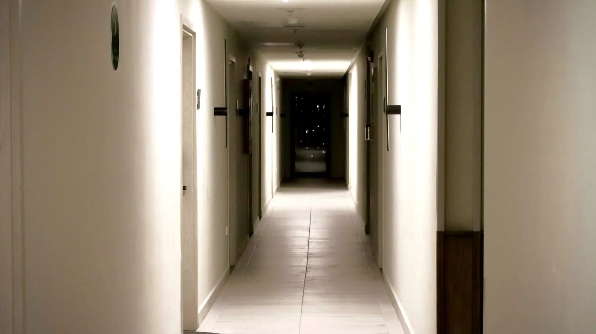 A plain apartment-building hallway lined with doors
